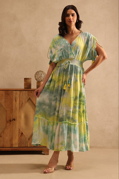 Woman wearing a tie-dye dress from Desi Tassels in a warm-toned room.