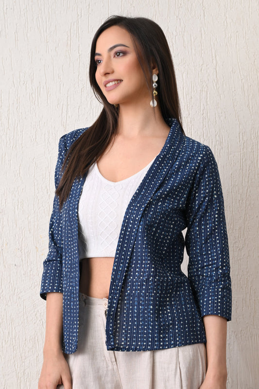 Woman wearing a blue patterned jacket from Desi Tassels over a white top against a neutral background